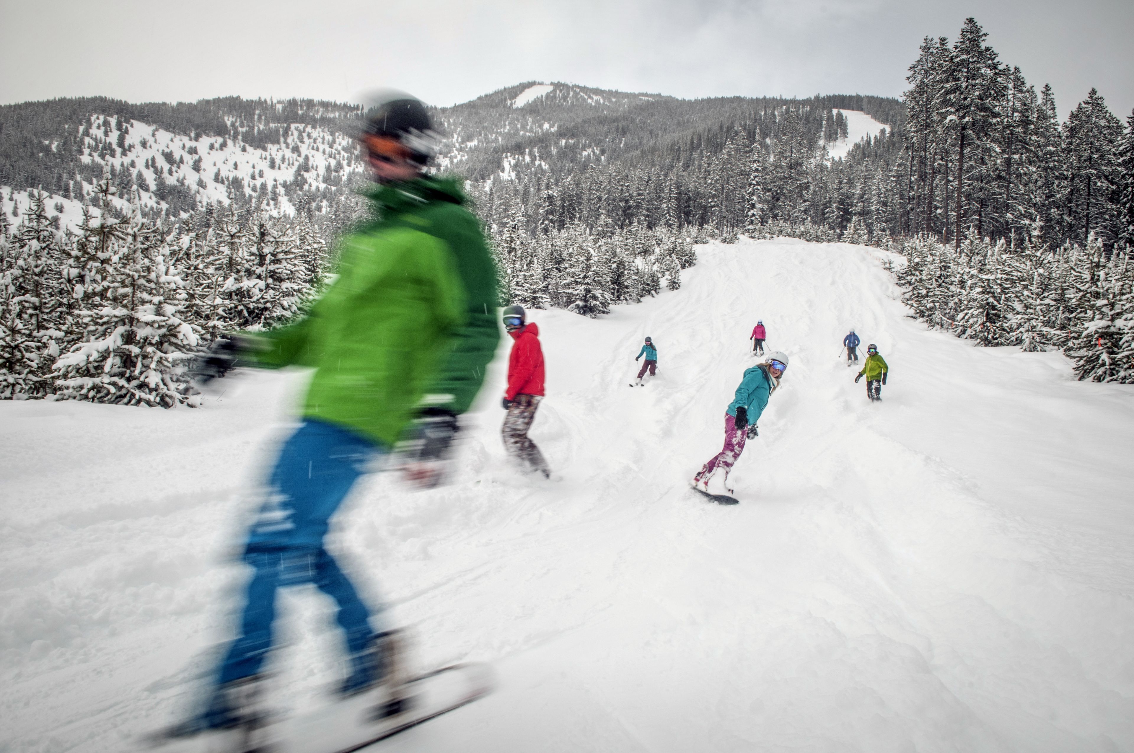 A snowy mountain slope with skiers and snowboarders.