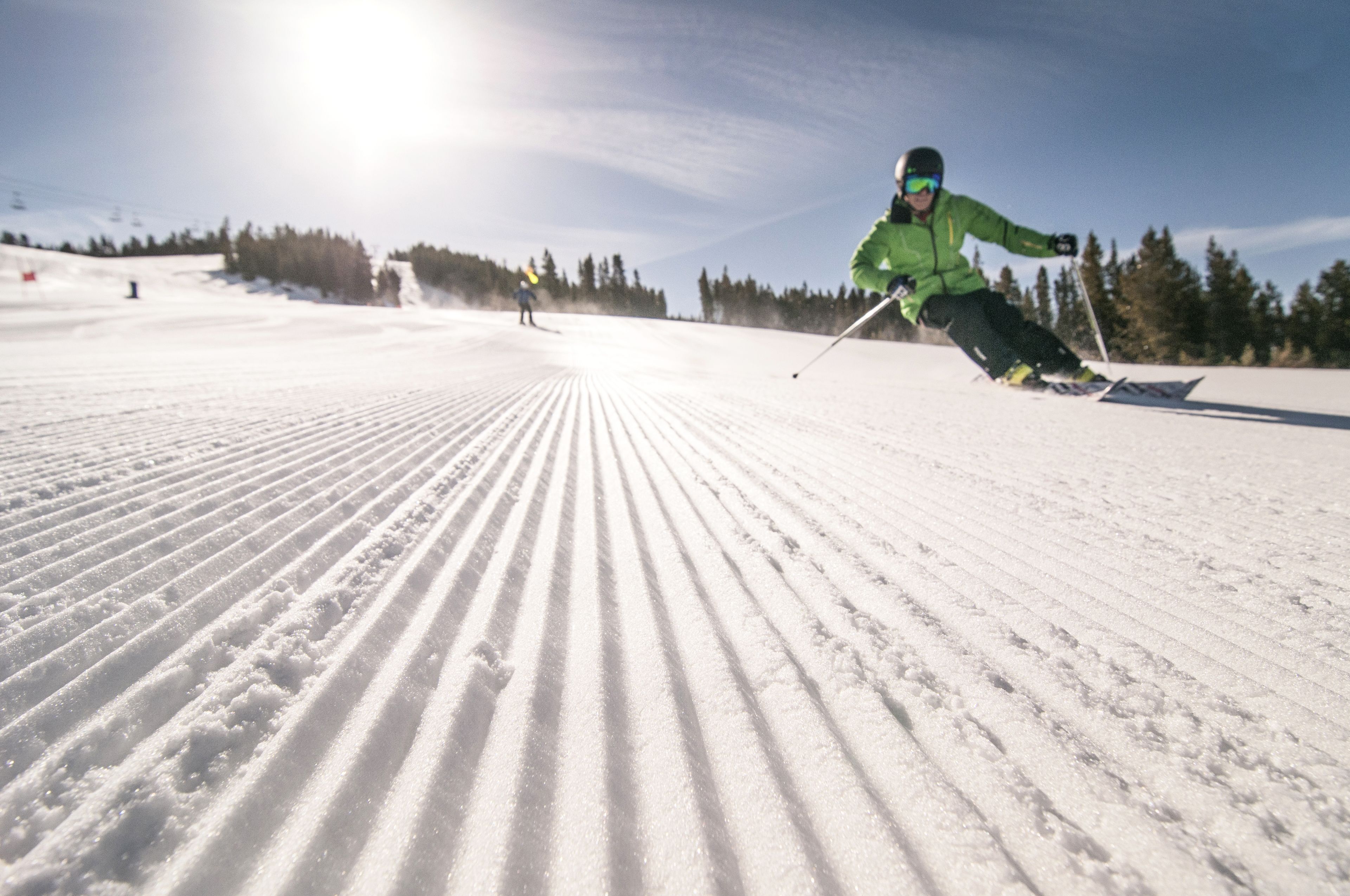 A ski slope with a skier in motion.