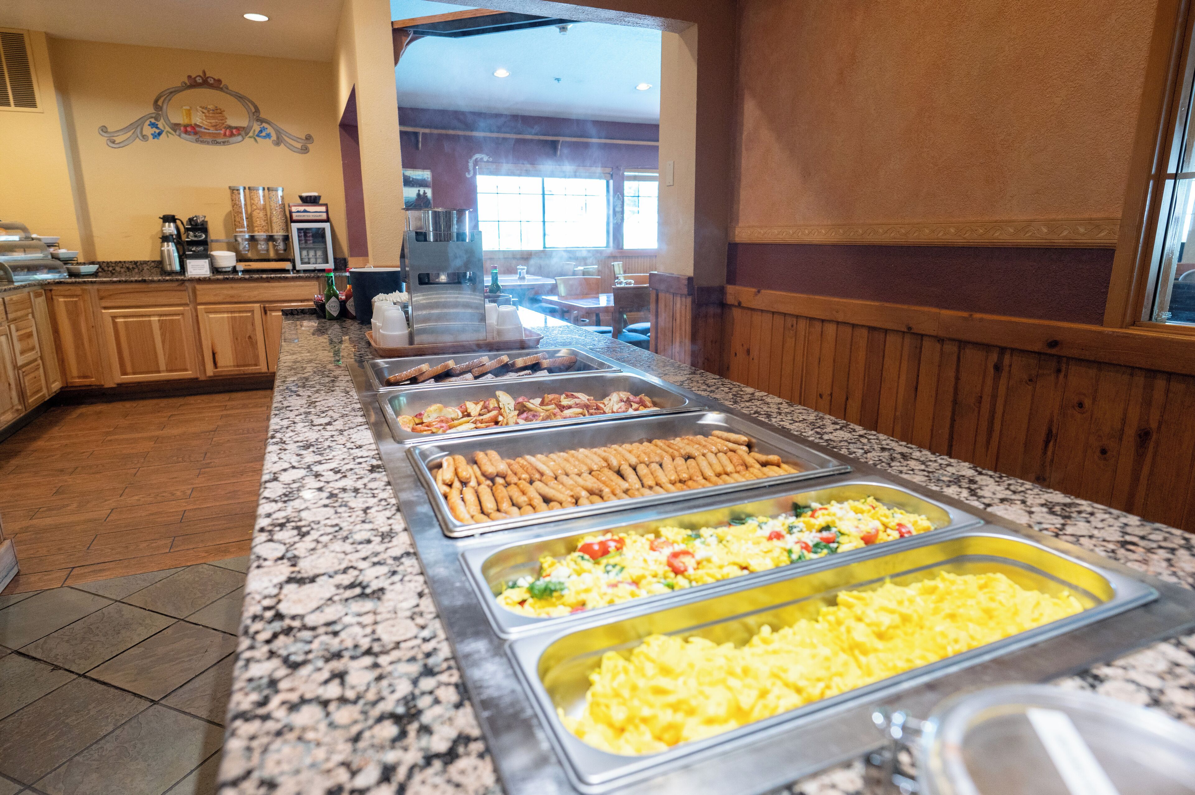 Een buffet met diverse gerechten, waaronder vlees, groenten en roerei.