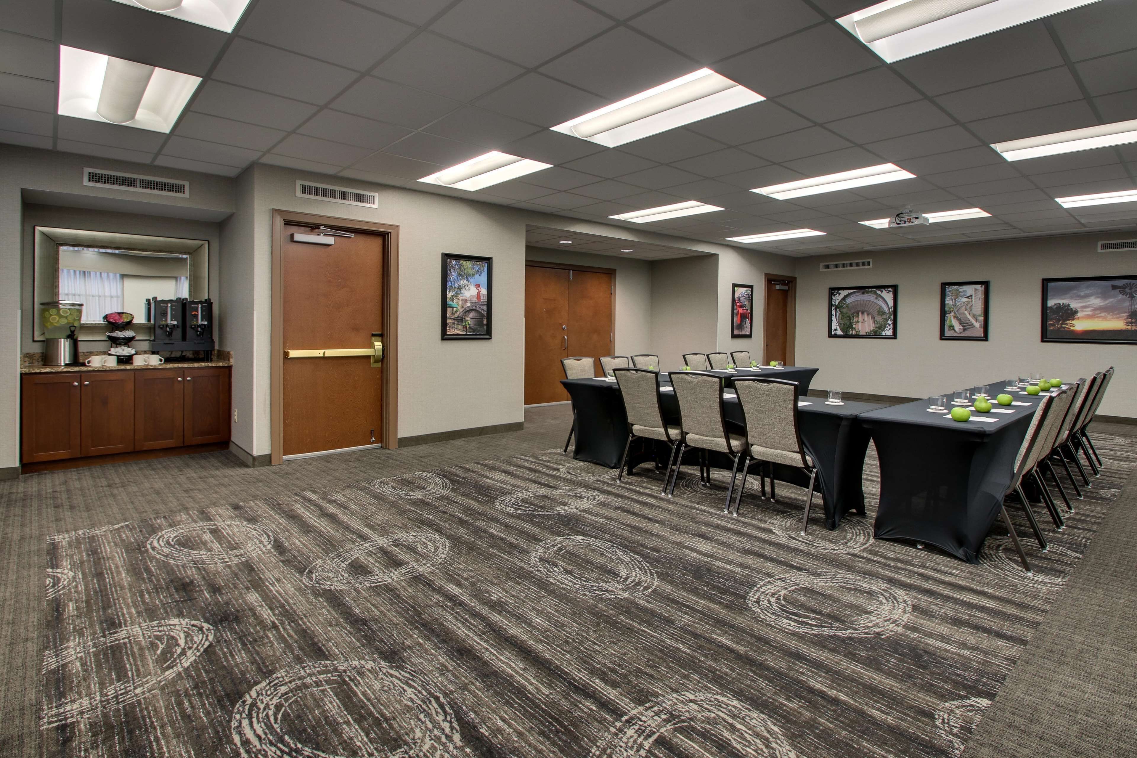 A conference room with a long table, chairs, and a carpeted floor.