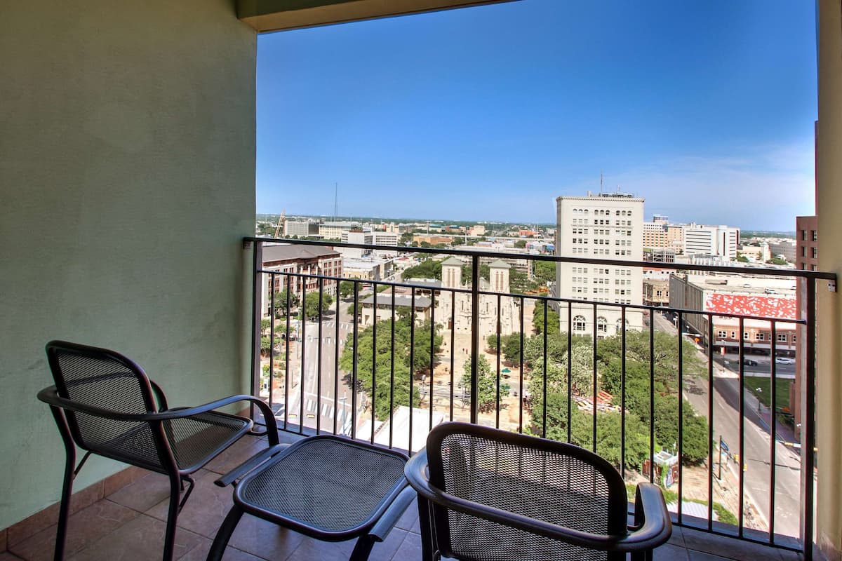 Un balcon avec deux chaises et une vue sur le paysage urbain.