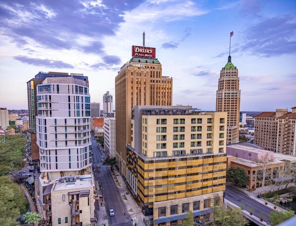 A cityscape with a prominent building featuring a sign for 'DRURY Plaza Hotel.'
