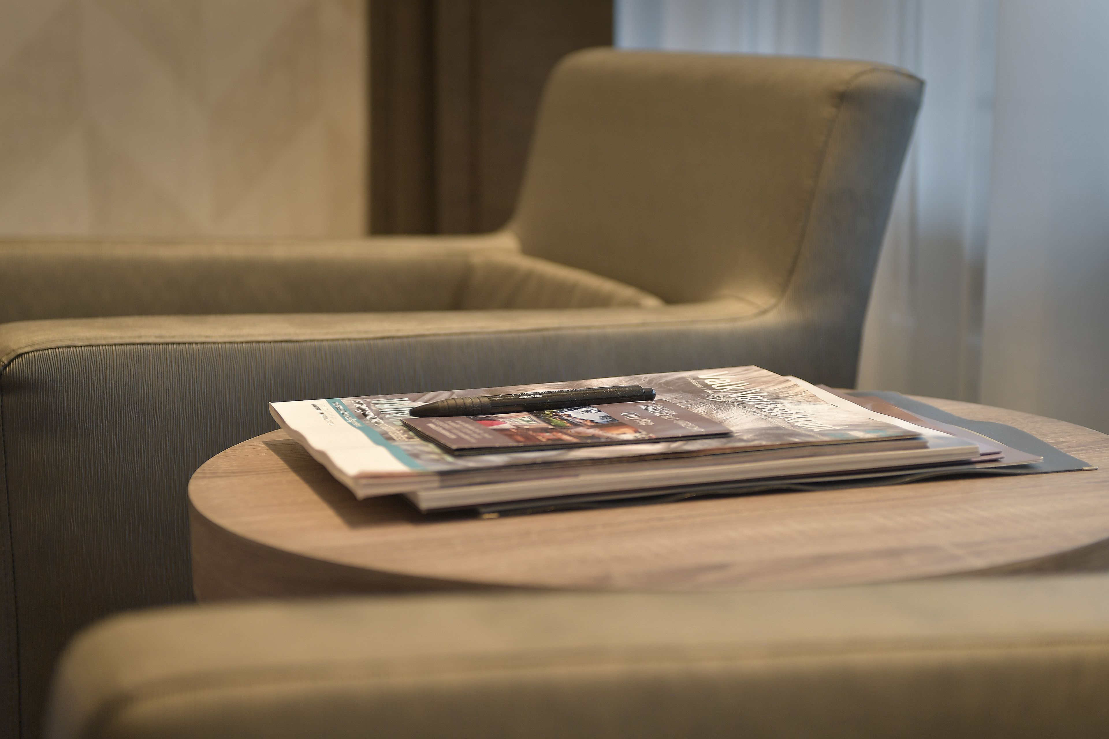 A seating area with a cushioned chair and a small wooden table.