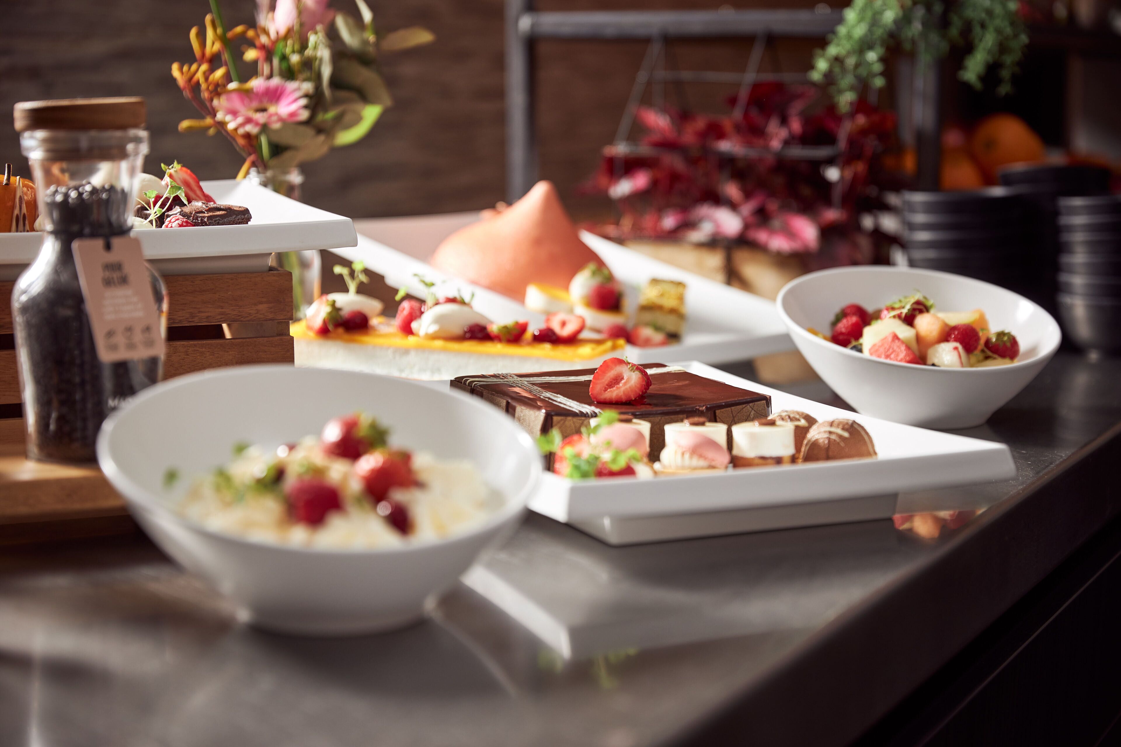 Diversos alimentos sobre una mesa, con tazones y platos que contienen postres y frutas.