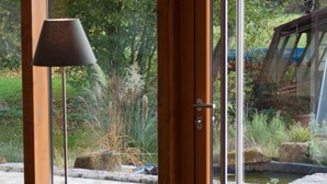 A room with a large sliding glass door leading to a garden. - Schloss Burgellern (Schesslitz)