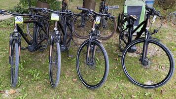 Bicycles parked in a grassy area with a sign that reads "PEARHRADER".