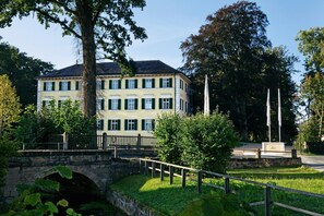 A two-story building with a stone bridge in front. - Schloss Burgellern (Schesslitz)