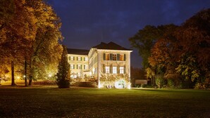 A large, multi-story building with a symmetrical facade, a central entrance with steps, and a well-maintained lawn in front. - Schloss Burgellern (Schesslitz)