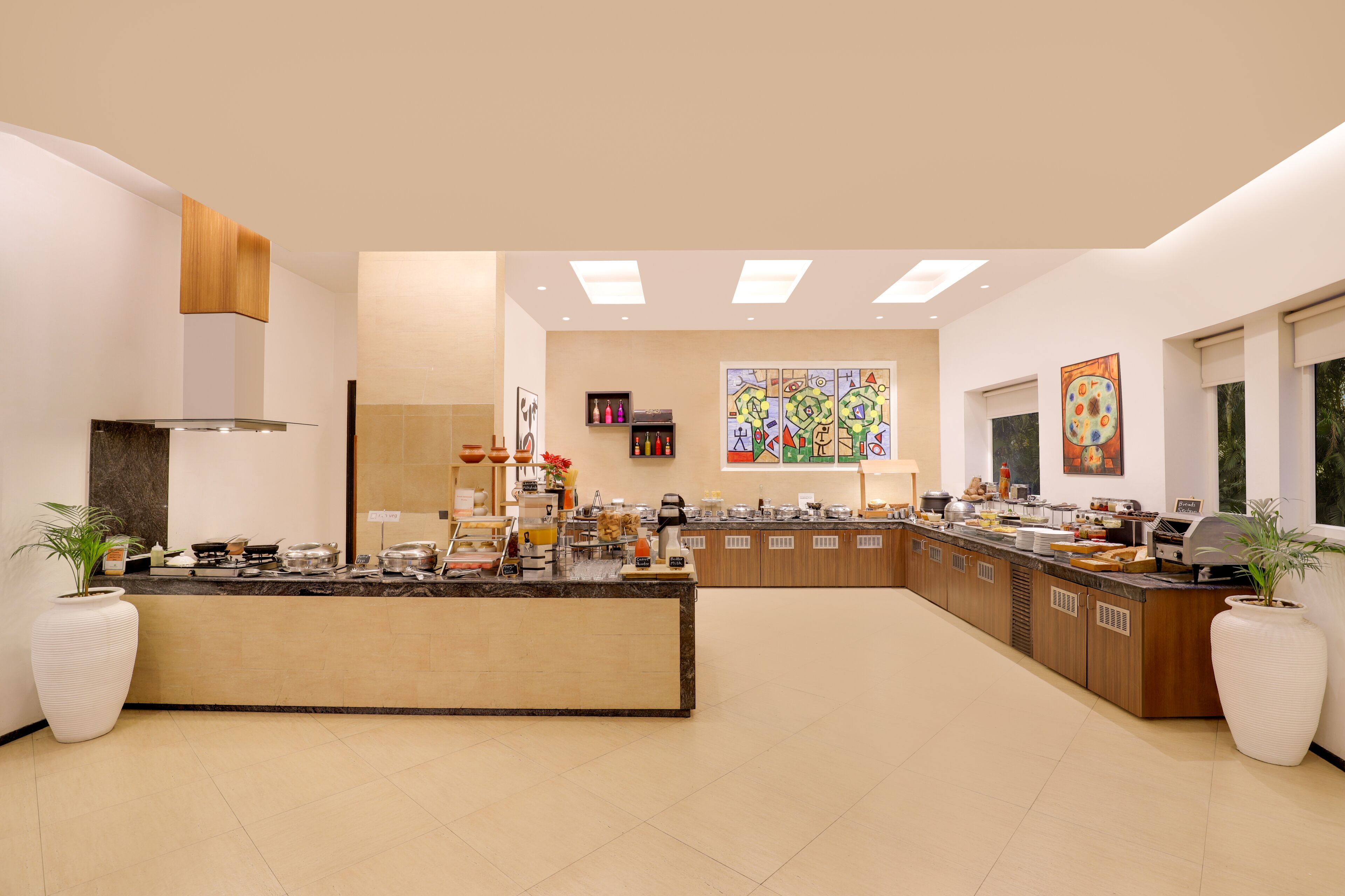 Una cocina moderna con una isla central, armarios de madera y un amplio ventanal que proporciona luz natural.