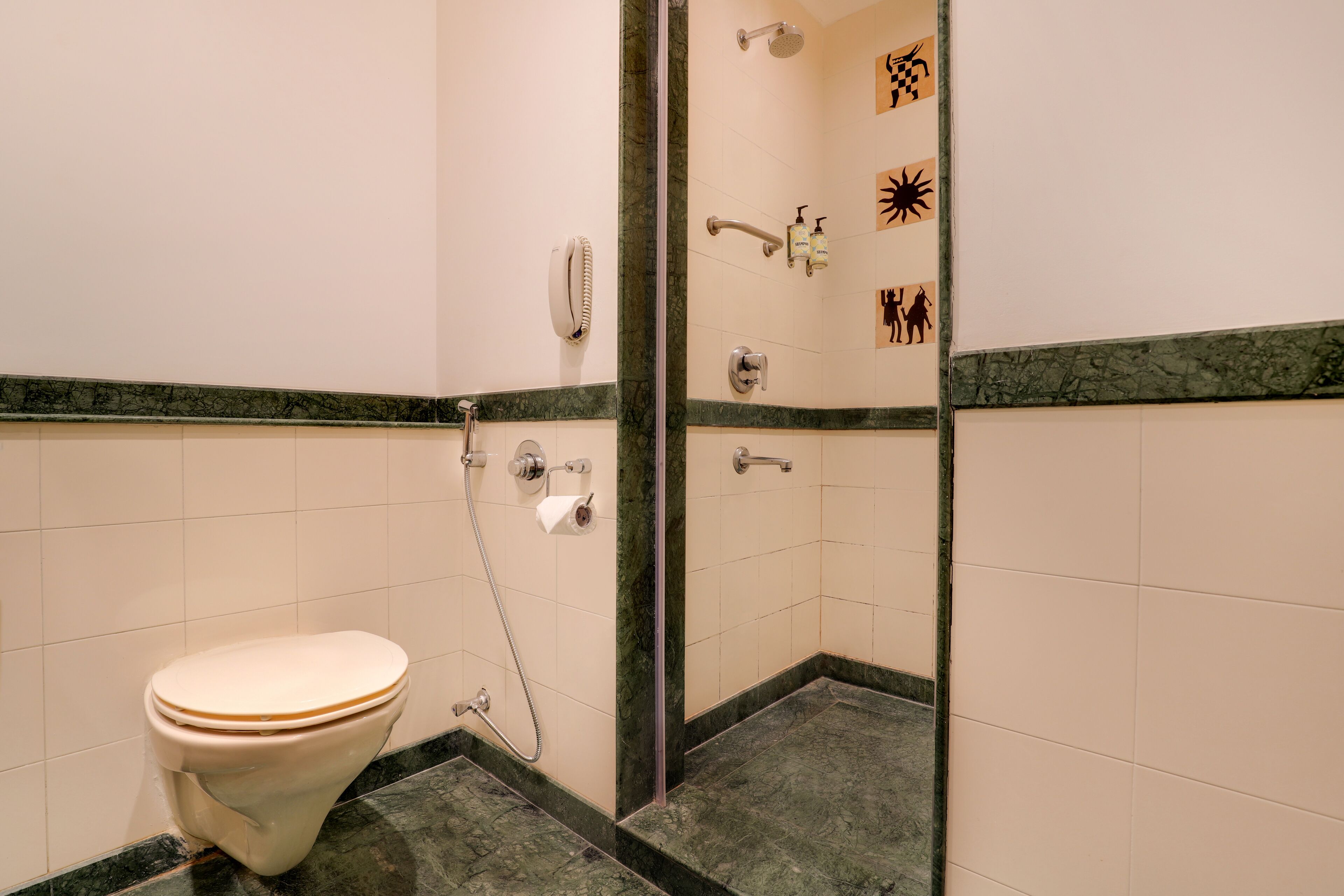 A bathroom with a toilet, shower, and a wall with symbols.