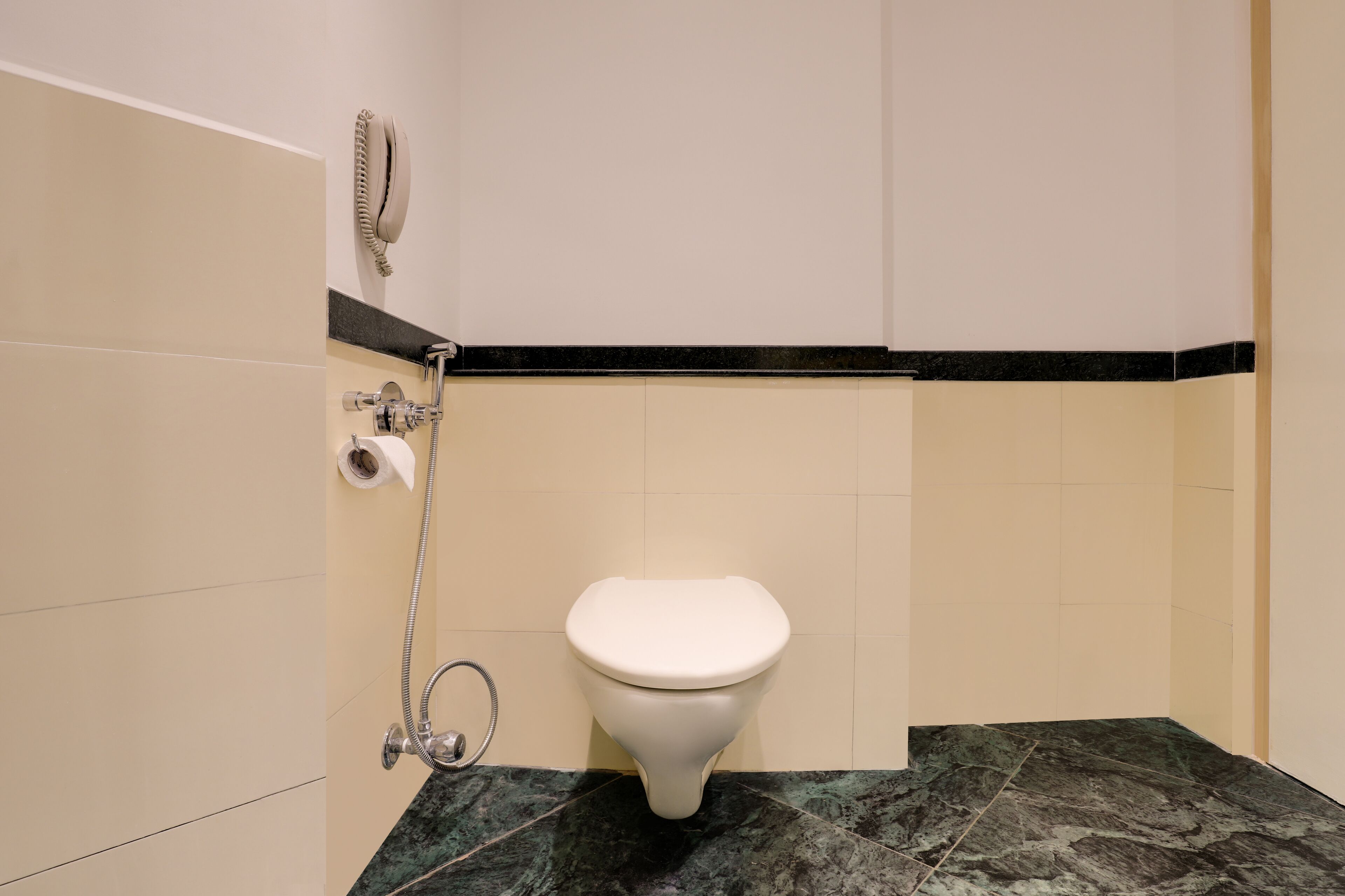 A bathroom with a toilet, a shower, and a towel rack.