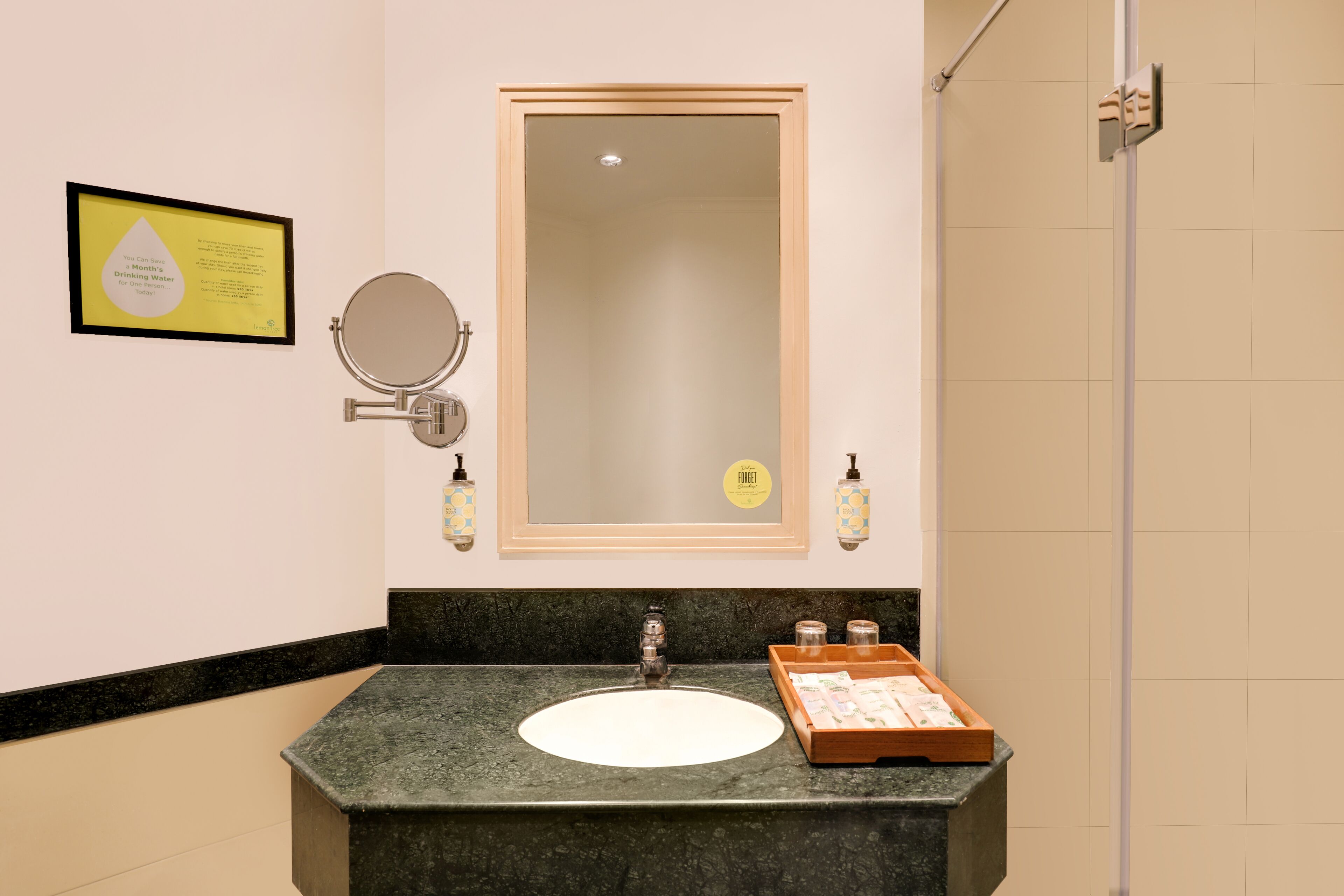 Ein Badezimmer mit Granitplatte, Waschbecken, Spiegel und einem gerahmten Zertifikat an der Wand.
