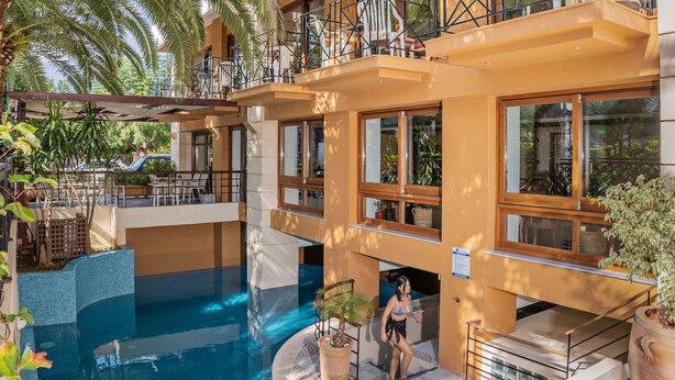 Zona de piscina con vista despejada, sillas de descanso alrededor y una escalera que lleva a un nivel superior.