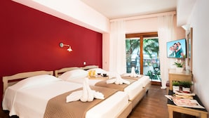 Habitación de hotel con dos camas, televisión y balcón con vistas a palmeras.