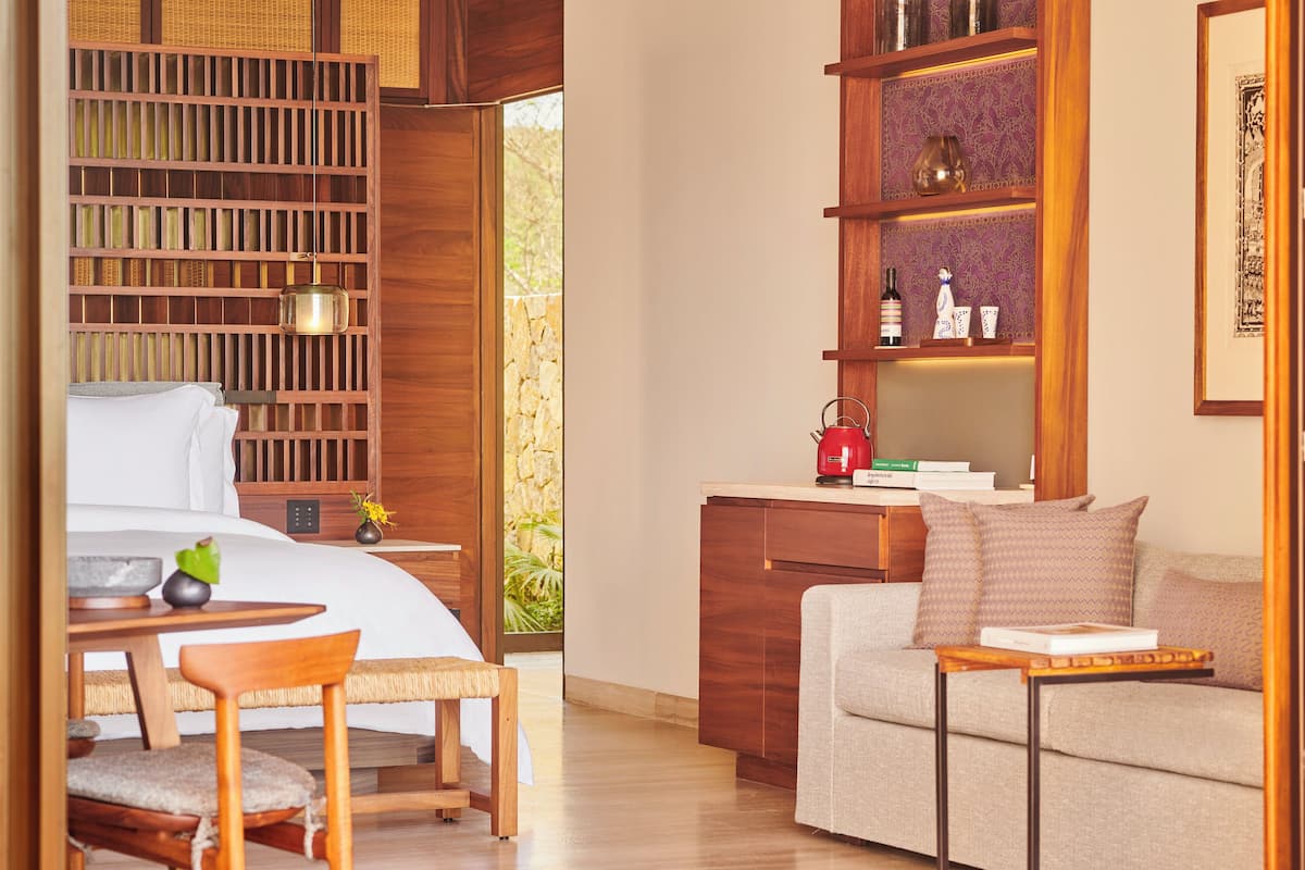 Une chambre d’hôtel moderne, équipée d’un lit, de meubles en bois, d’un bureau et d’une bibliothèque.