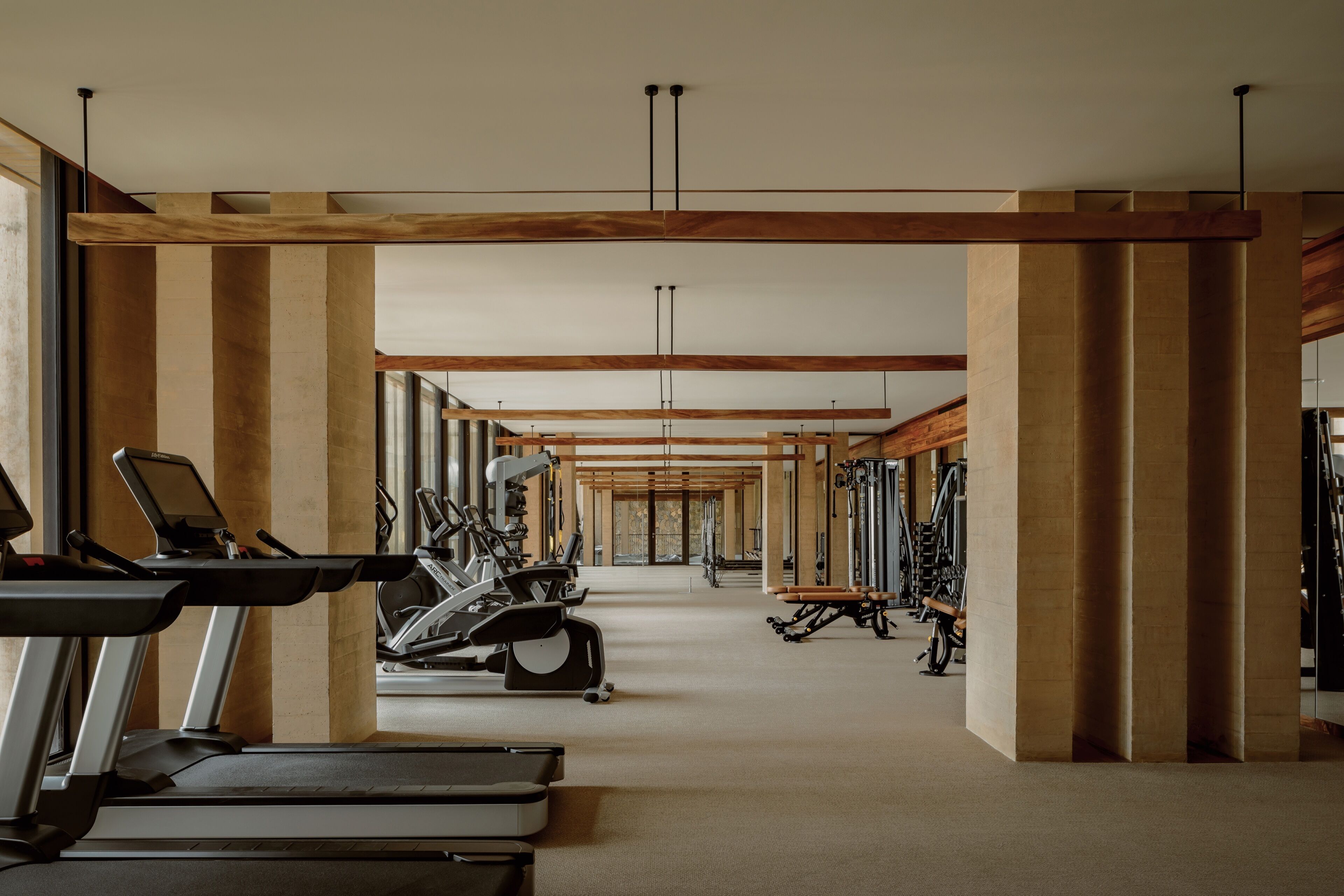 Un gimnasio con cintas de correr, elípticas y equipo de pesas.