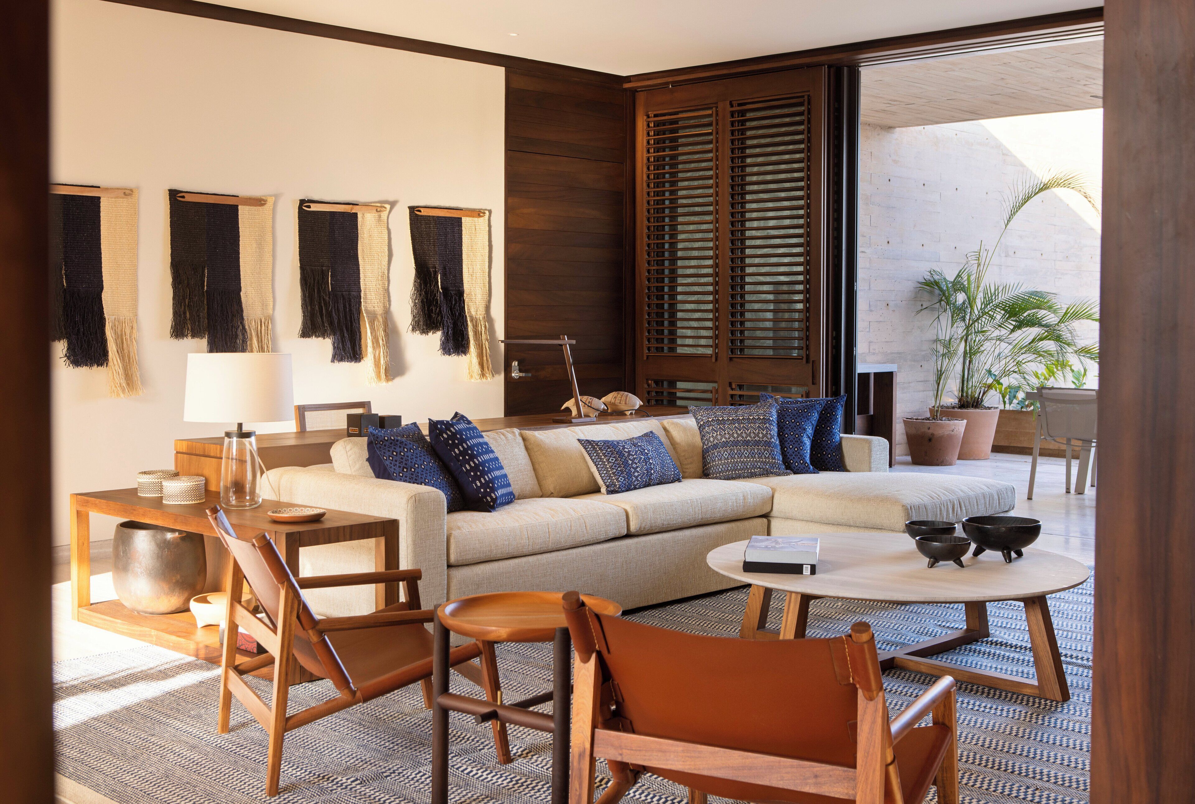 Uma sala de estar moderna com sofá, cadeiras, mesa de centro e área de jantar.