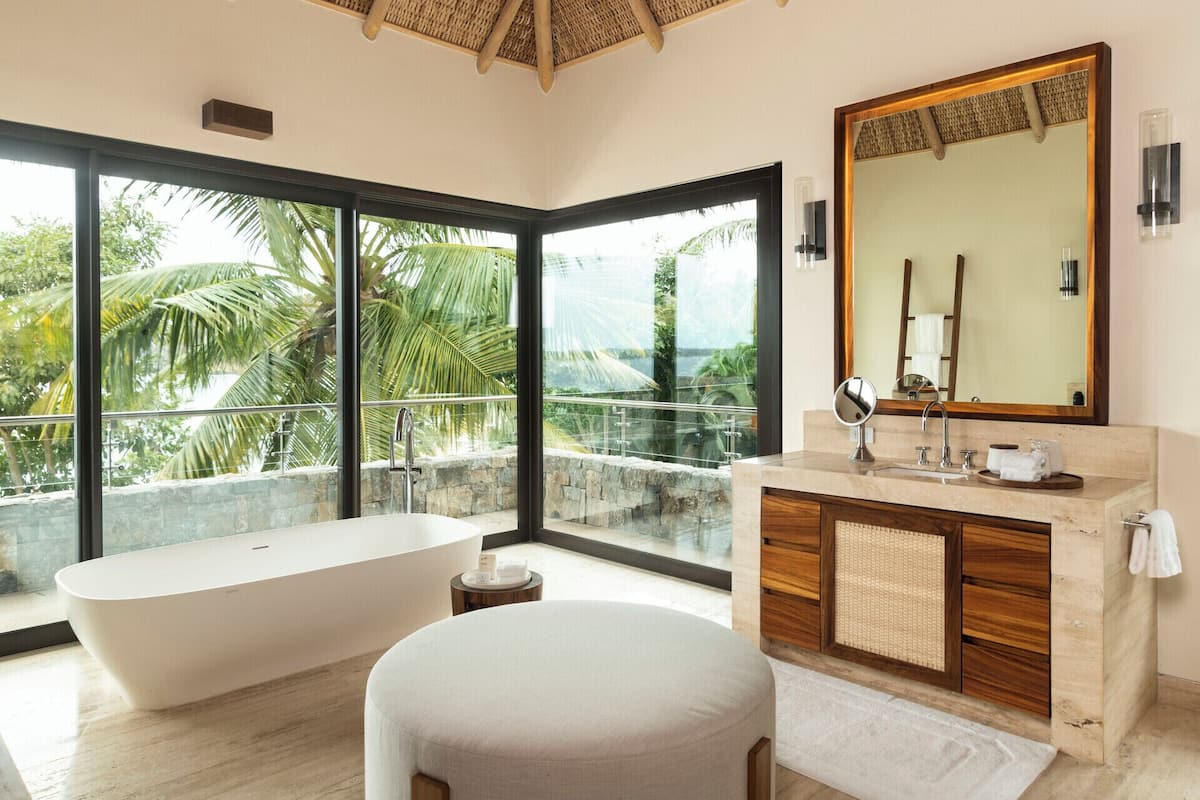 Une salle de bain moderne avec une baignoire sur pieds, un grand miroir et un meuble-lavabo.