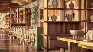 Un restaurante con mobiliario de madera y estantes que exhiben cerámica.