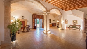 A spacious interior with high ceilings, wooden beams, and a stone archway. - Finca Son Roig by Valentin (Porreres)
