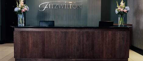 Un mostrador de recepción con el nombre 'Fitzwilton' al fondo.
