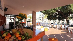 An outdoor seating area with a fruit bowl, tables, and chairs. - Balaia Plaza (Albufeira)