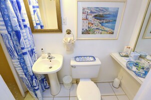 Un bagno con lavandino, WC e tenda della doccia.