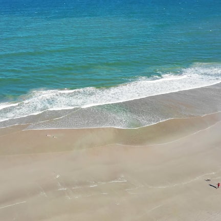 En la playa, playa de arena blanca, sombrillas y toallas de playa