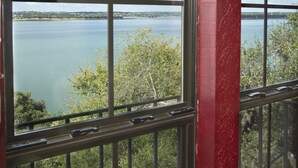 A large window with a view of a lake and distant shoreline. - The Lakehouse Bed & Breakfast (Canyon Lake)