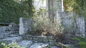 A stone pathway leading to an arched structure surrounded by greenery and stone walls. - The Lakehouse Bed & Breakfast (Canyon Lake)