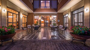 A hotel lobby with a checkered floor, multiple seating areas, and potted plants. - Hotel Frate Sole (Assisi)