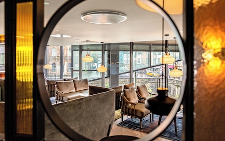 A modern interior with leather seating and large windows offering city views.