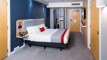 A hotel room with a bed, bedside table, and a telephone.
