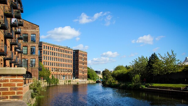 A river with buildings on one side and greenery on the other. - Holiday Inn Express Leeds City Centre Armouries by IHG (Leeds)
