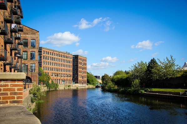 A river with buildings on one side and greenery on the other. - Holiday Inn Express Leeds City Centre Armouries by IHG (Leeds)