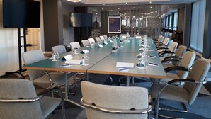 A conference room with a long table, chairs, and a TV screen. - Holiday Inn Express Leeds City Centre Armouries by IHG (Leeds)
