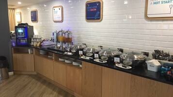 Un espace buffet proposant une variété de plats et une machine à café.