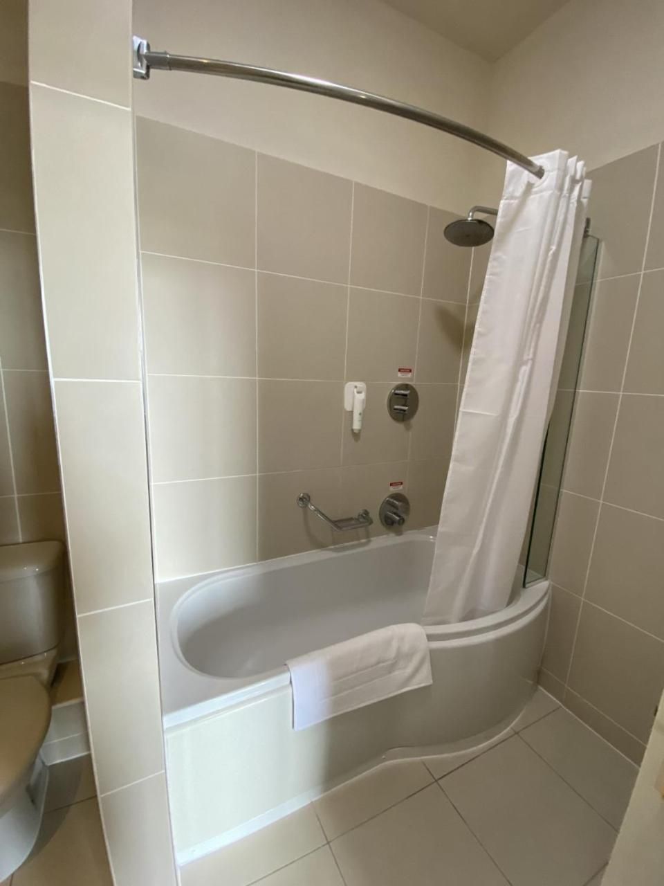 Un bagno moderno con cabina doccia a semicircolo, una vasca da bagno e un water.