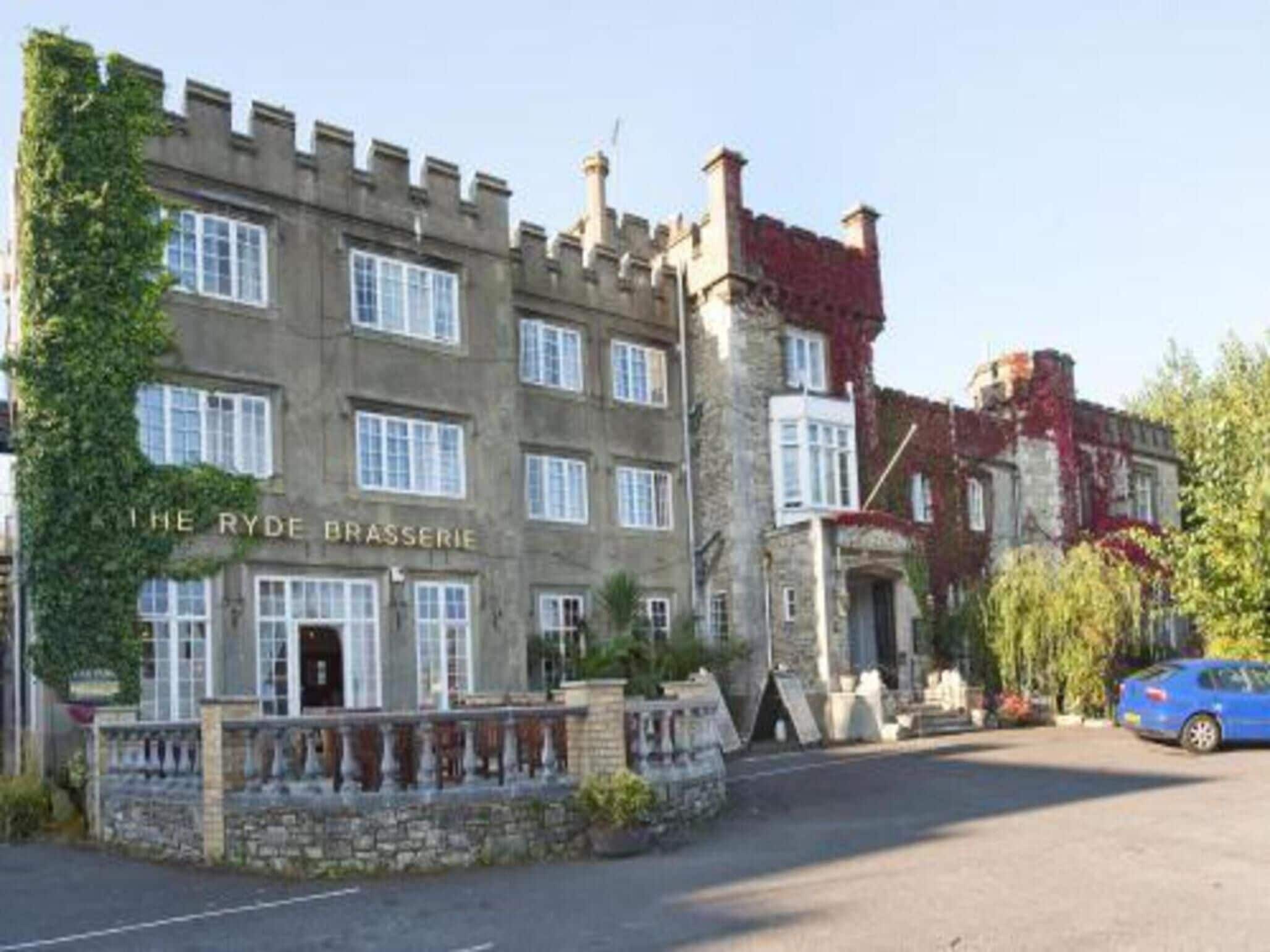 A historic building with a stone facade, multiple windows, and a sign reading "The Ryder Brasserie".