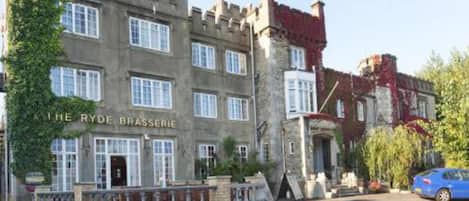 A historic building with a stone facade, multiple windows, and a sign reading "The Ryder Brasserie".