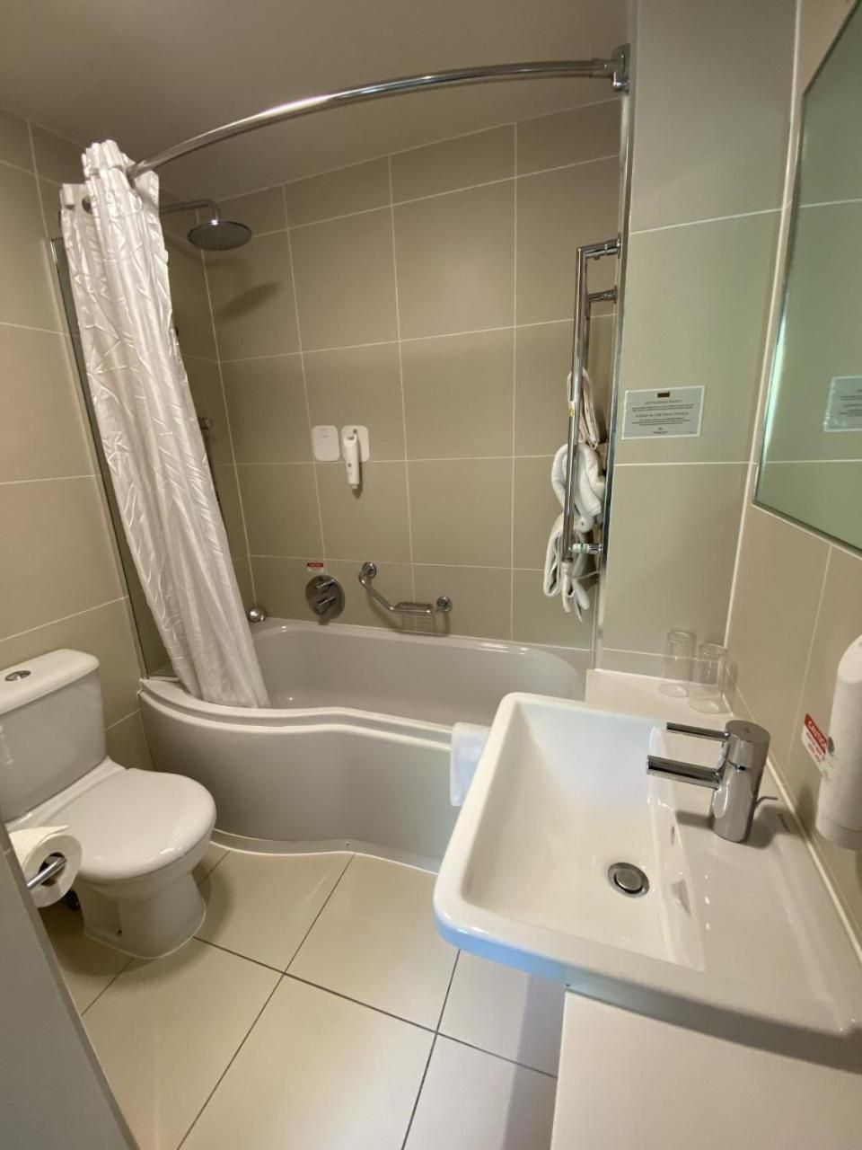 Un bagno con doccia, servizi igienici e lavandino.