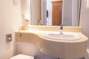 A bathroom with a white sink, a mirror, and a toilet. - The Roebuck Hotel by Greene King Inns (Forest Row)