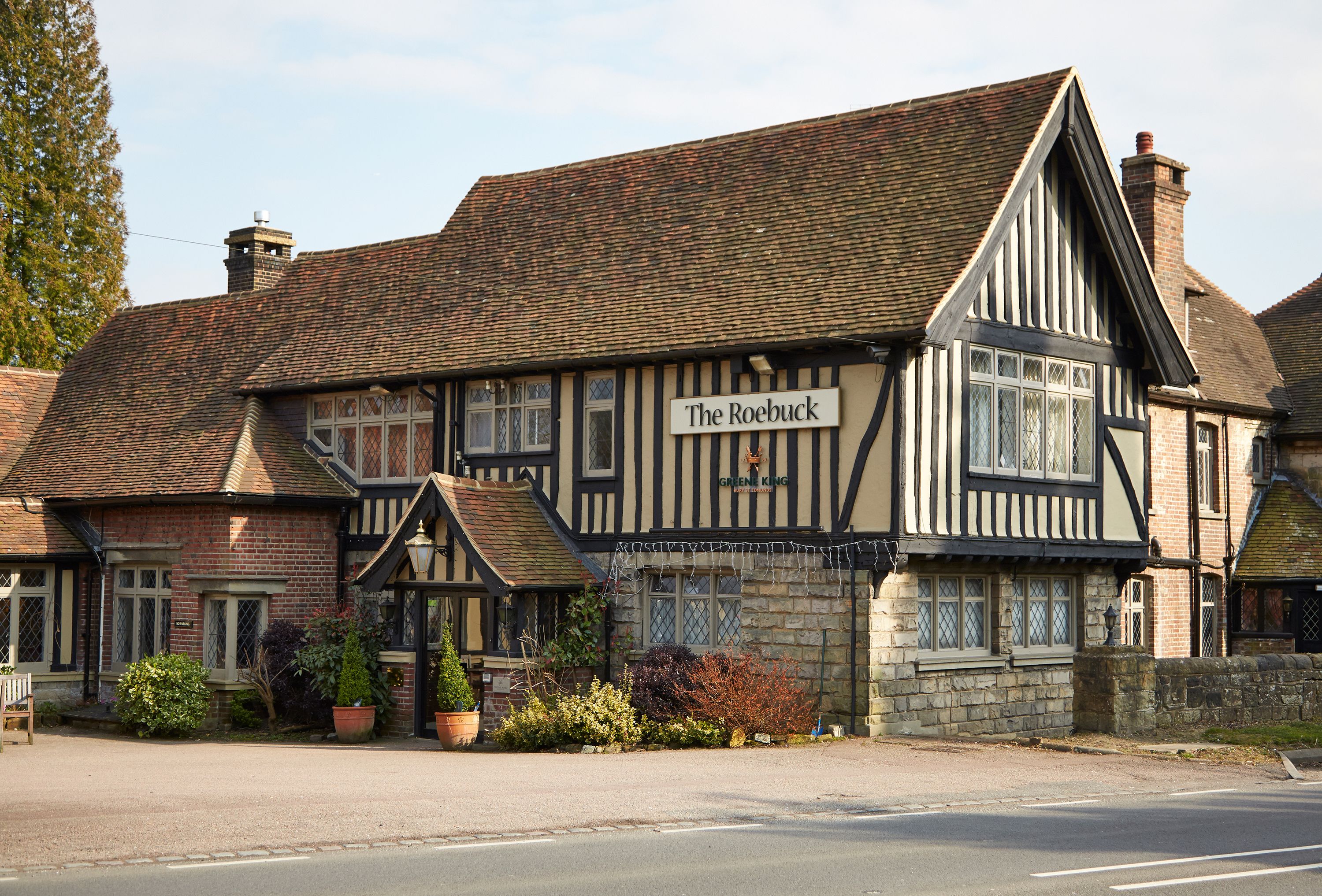 Un edificio de estilo Tudor tradicional con un letrero que dice "The Roebuck".