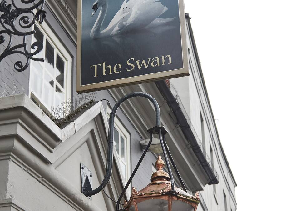 Een gebouw met een bord waarop 'The Swan' staat.