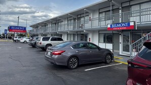 A motel with a sign reading "BELMONT INN & SUITES" and a parking lot with several cars. - Belmont Inn And Suites (Virginia Beach)