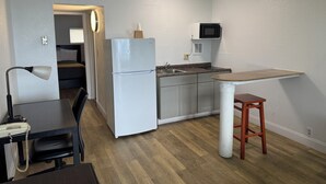 A compact kitchen with a refrigerator, microwave, and sink. - Belmont Inn And Suites (Virginia Beach)