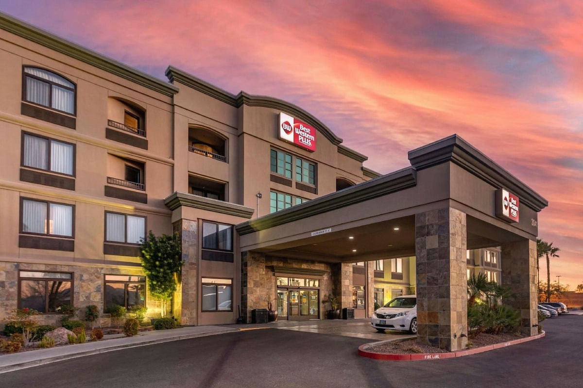 Un hotel de varios pisos con entrada despejada, un letrero que indica que es un Best Western Plus y un estacionamiento con pasillo contra incendios.