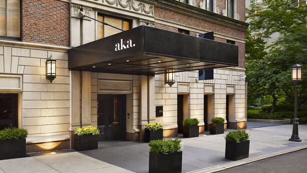 A hotel entrance with a black awning, numbered 330, and a brick facade.