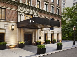 A hotel entrance with a black awning, numbered 330, and a brick facade. - AKA Sutton Place (New York)