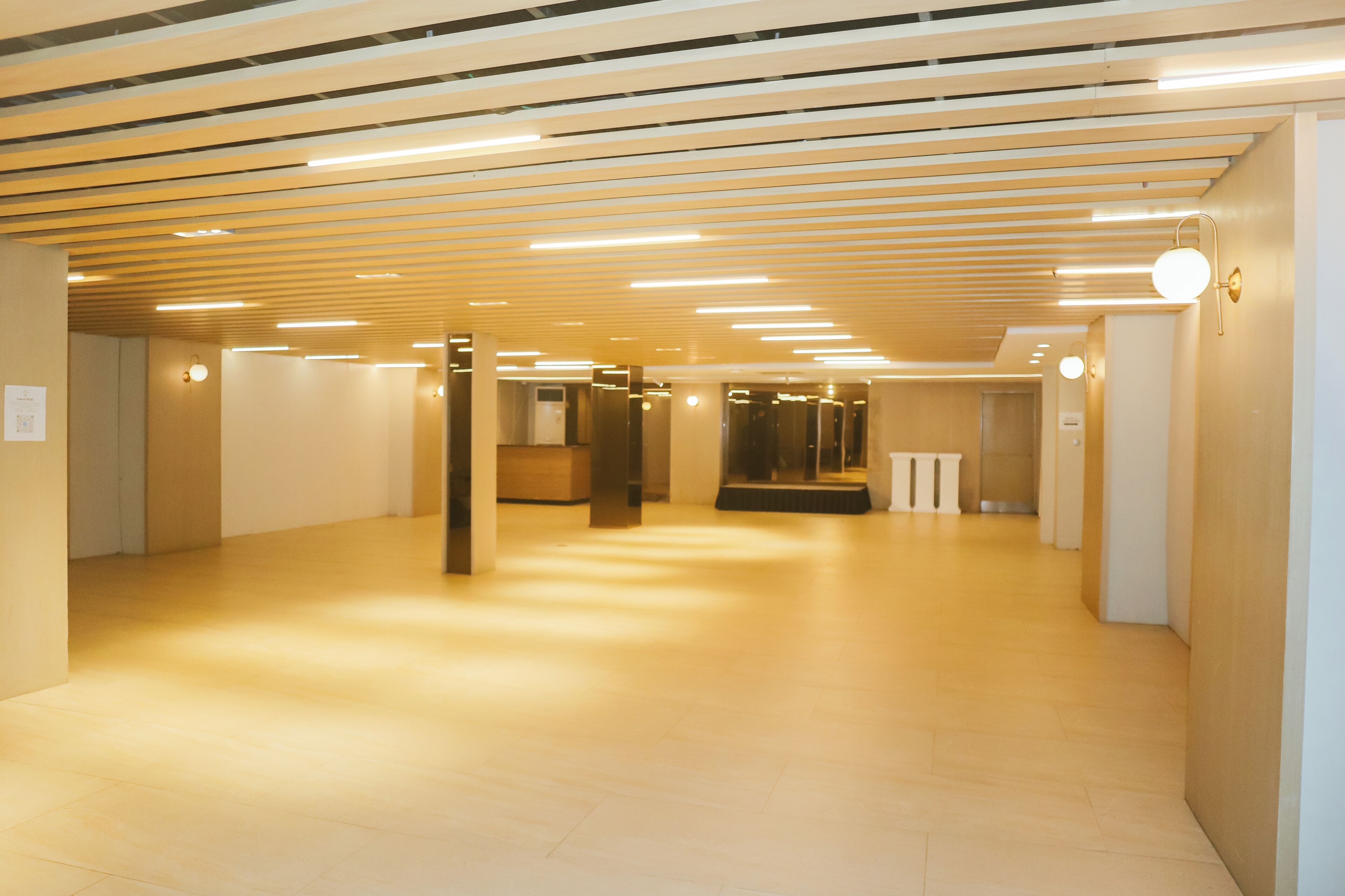 Un vaste couloir doté d’un plafond en bois et d’un éclairage moderne.